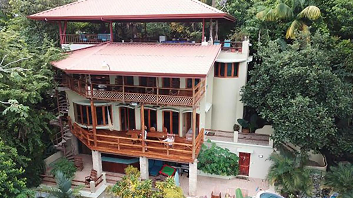 Front view of Casa Pura Paz showing three levels of decks under red tile roofs