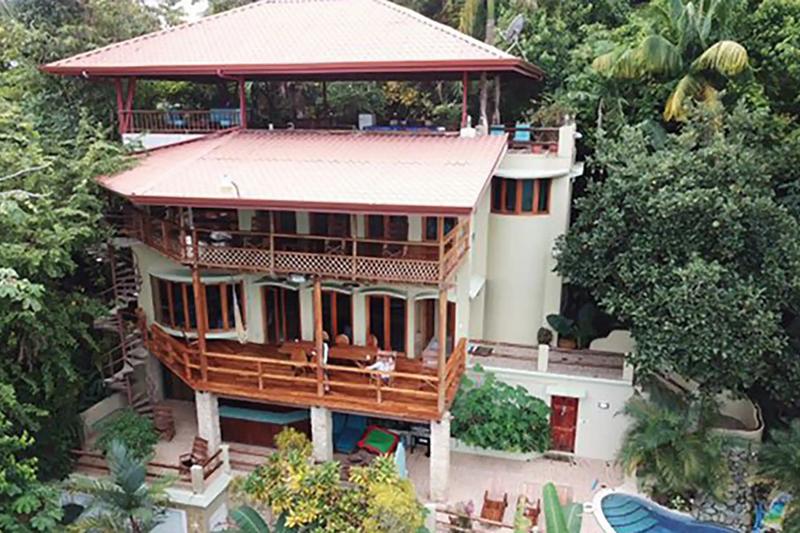 Front view of Casa Pura Paz showing three levels of decks under red tile roofs