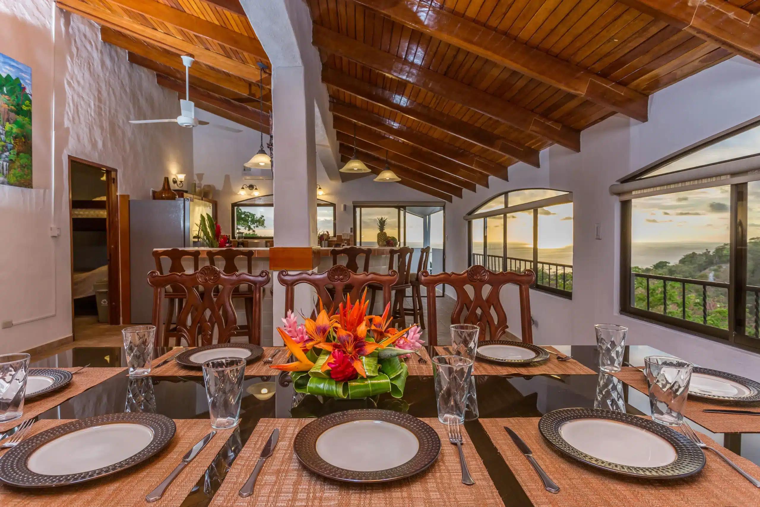 Tropical flower centerpiece on the Casa Moreno dining table with sunset ocean views