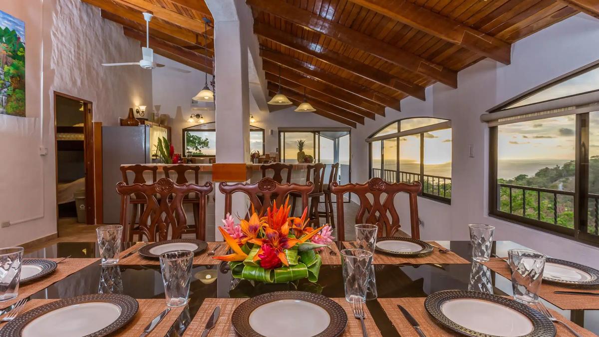 Tropical flower centerpiece on the Casa Moreno dining table with sunset ocean views