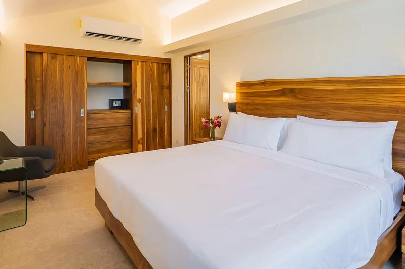 Casa Dos Cascadas bedroom with sliding teak closet doors and reading chair