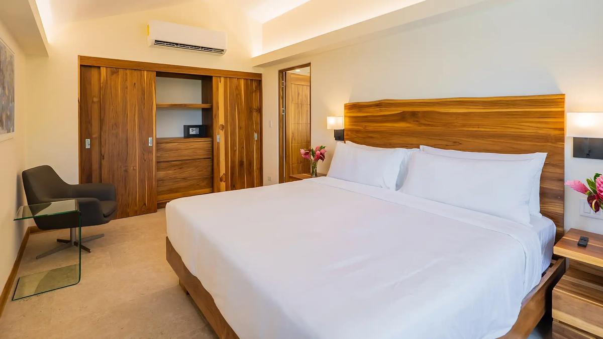 Casa Dos Cascadas bedroom with sliding teak closet doors and reading chair