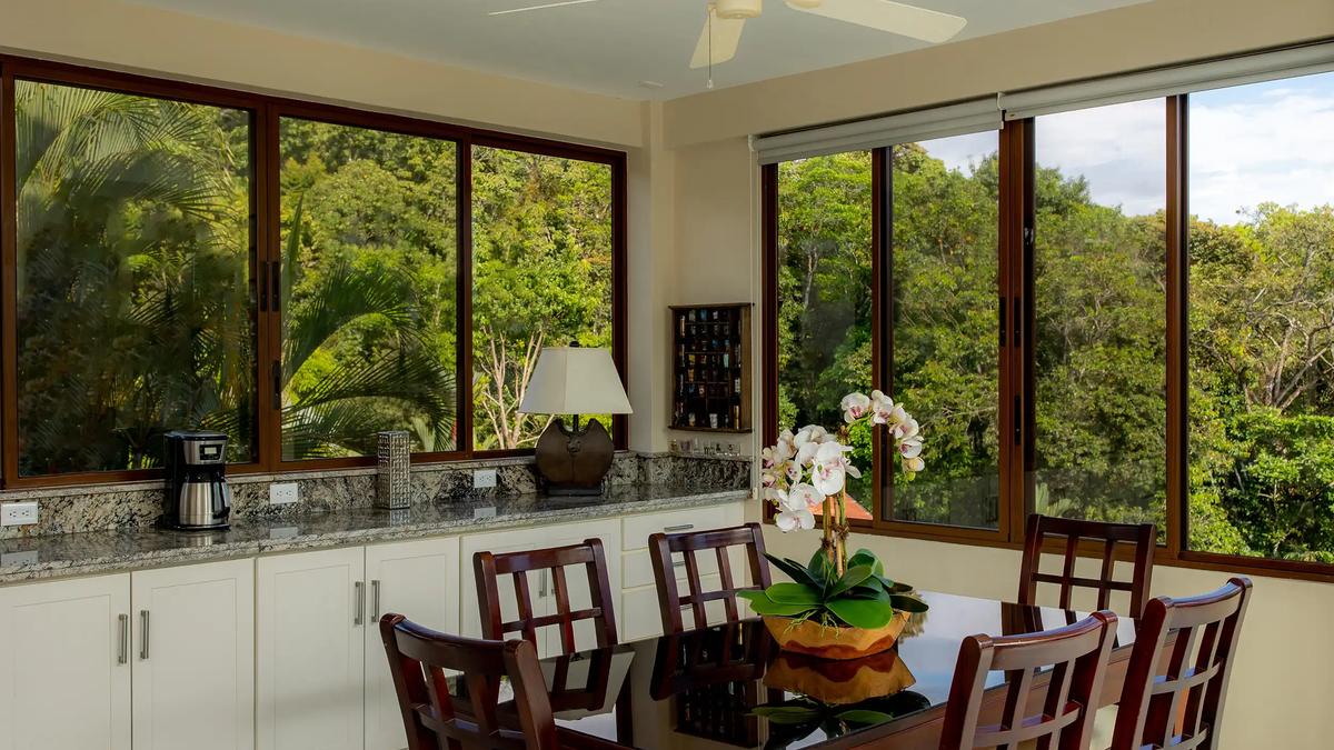 Dining area at Casa Mariposa with granite counters and rainforest window views