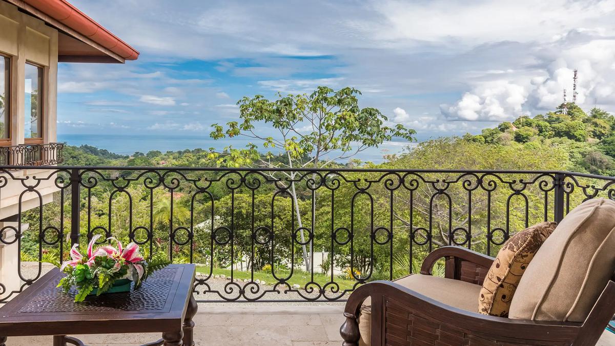 Balcony seating at Villa Marbella with iron railing and Pacific views beyond