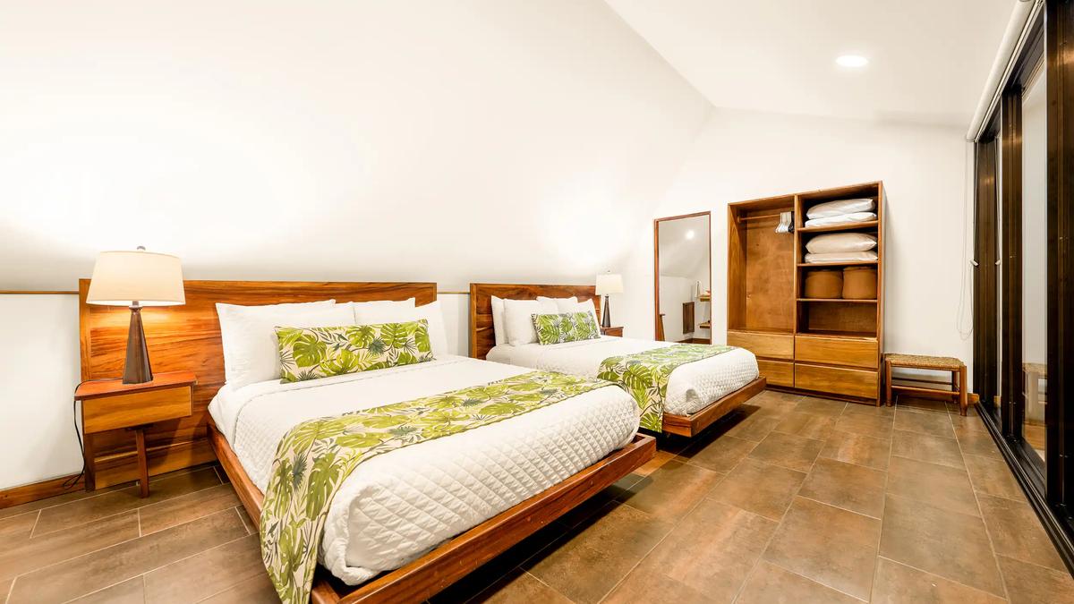 Two queen beds with tropical leaf runners in the Casa Vista Verde loft bedroom