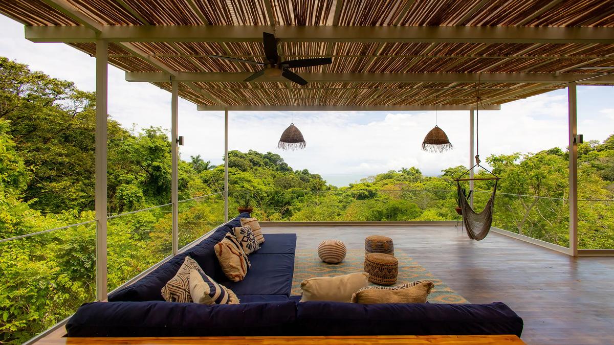 Sectional seating at Villa Caimito facing rainforest canopy and a distant ocean horizon
