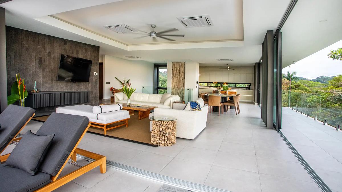 Open air living room at Casa Nueva Vida with loungers, stone media wall, and jungle outlook
