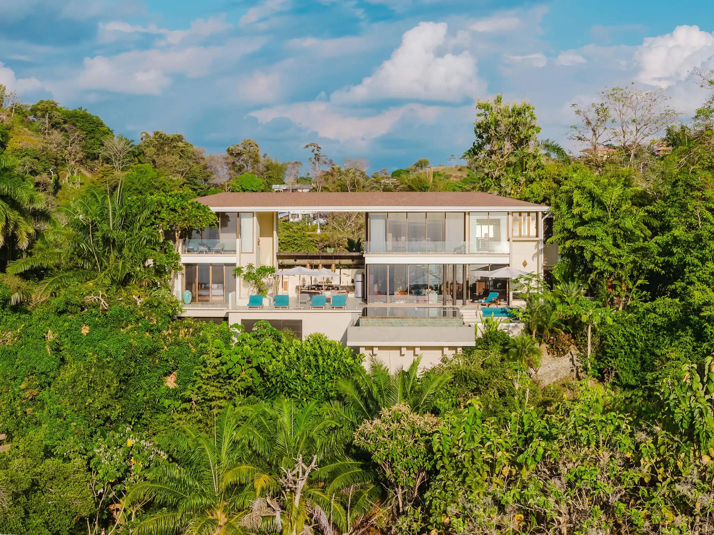 Aerial view of Casa Nola, a modern two story villa framed by rainforest canopy