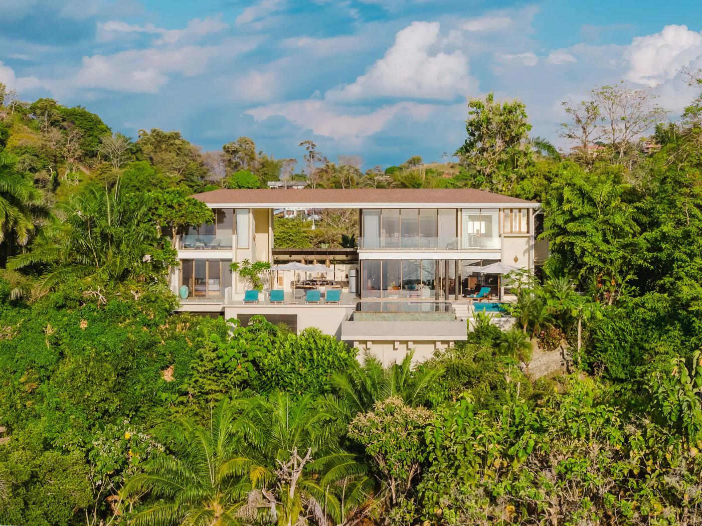 Aerial view of Casa Nola, a modern two story villa framed by rainforest canopy