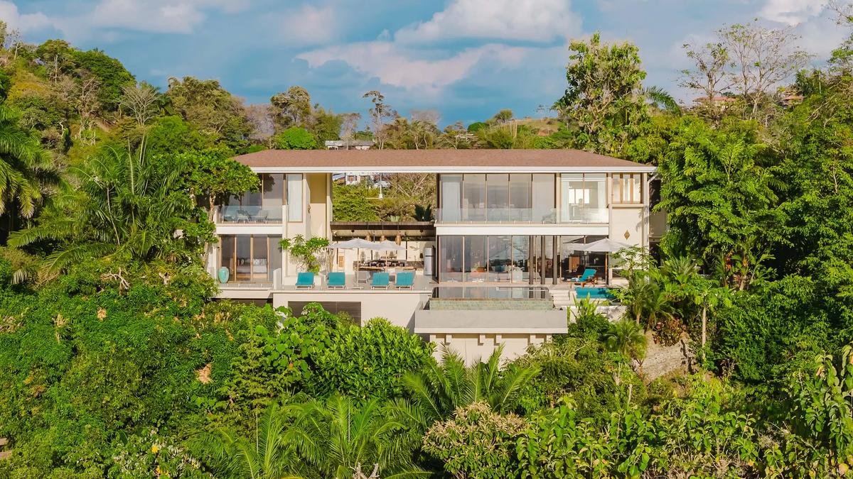 Aerial view of Casa Nola, a modern two story villa framed by rainforest canopy