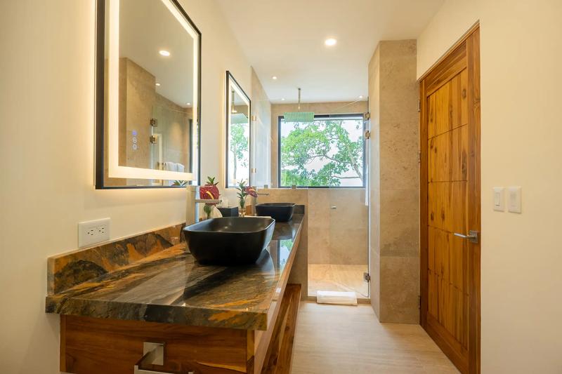 Master bathroom at Casa Rambutan with double black sinks and glass walk in shower