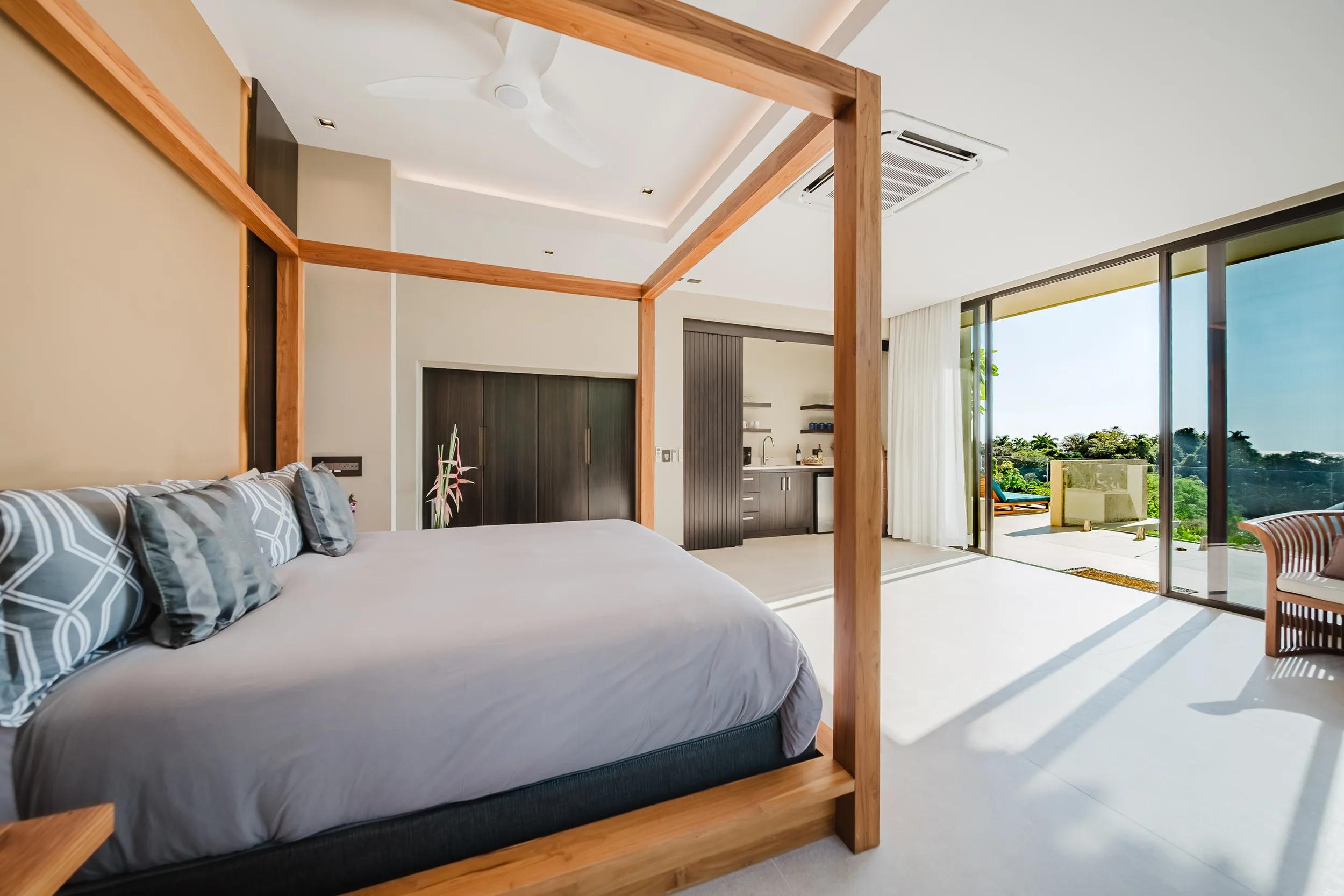 Timber four poster bed in a Casa Nola suite with sliding doors to the terrace