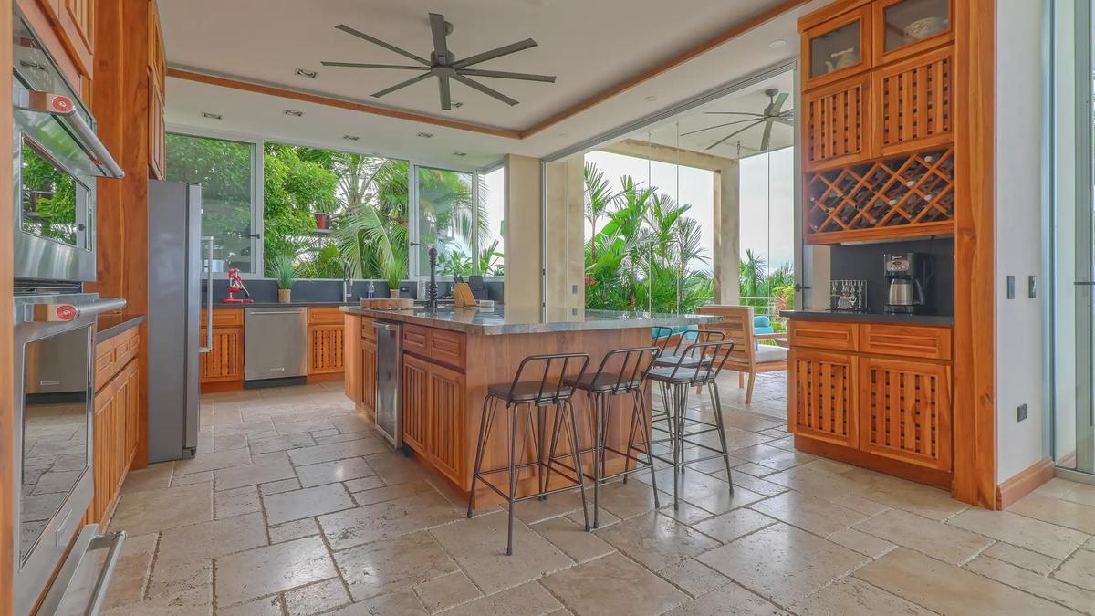 Teak kitchen at Casa Contee with island bar seating and jungle views