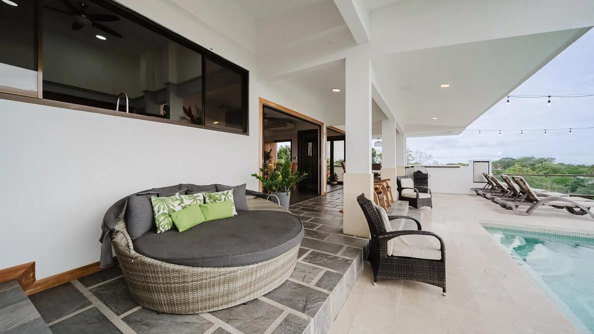Poolside terrace at Casa Grande Vista with round wicker daybed and loungers