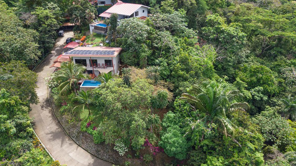Aerial view of Casa Serenidad on a forested hillside with neighboring villas