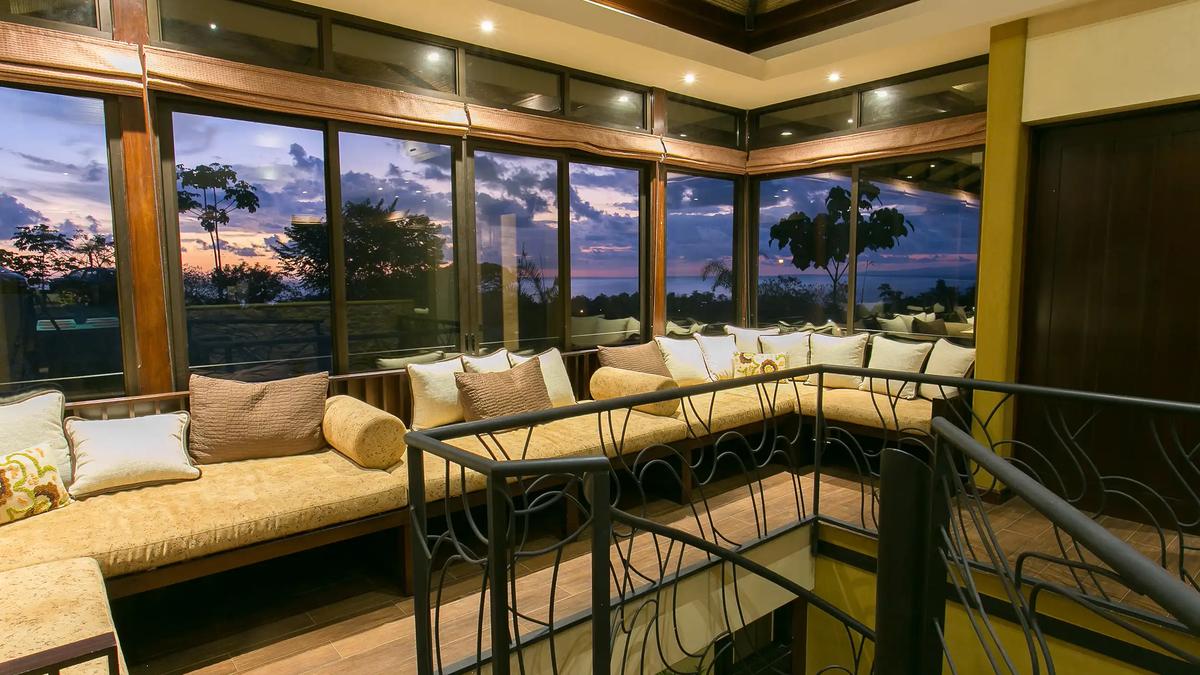 Upstairs lounge with wraparound windows facing the sunset over the Pacific at Casa Anaka