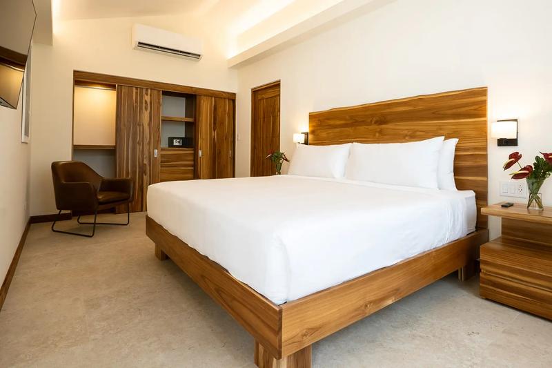King bedroom at Casa Rambutan with live edge teak headboard and leather armchair