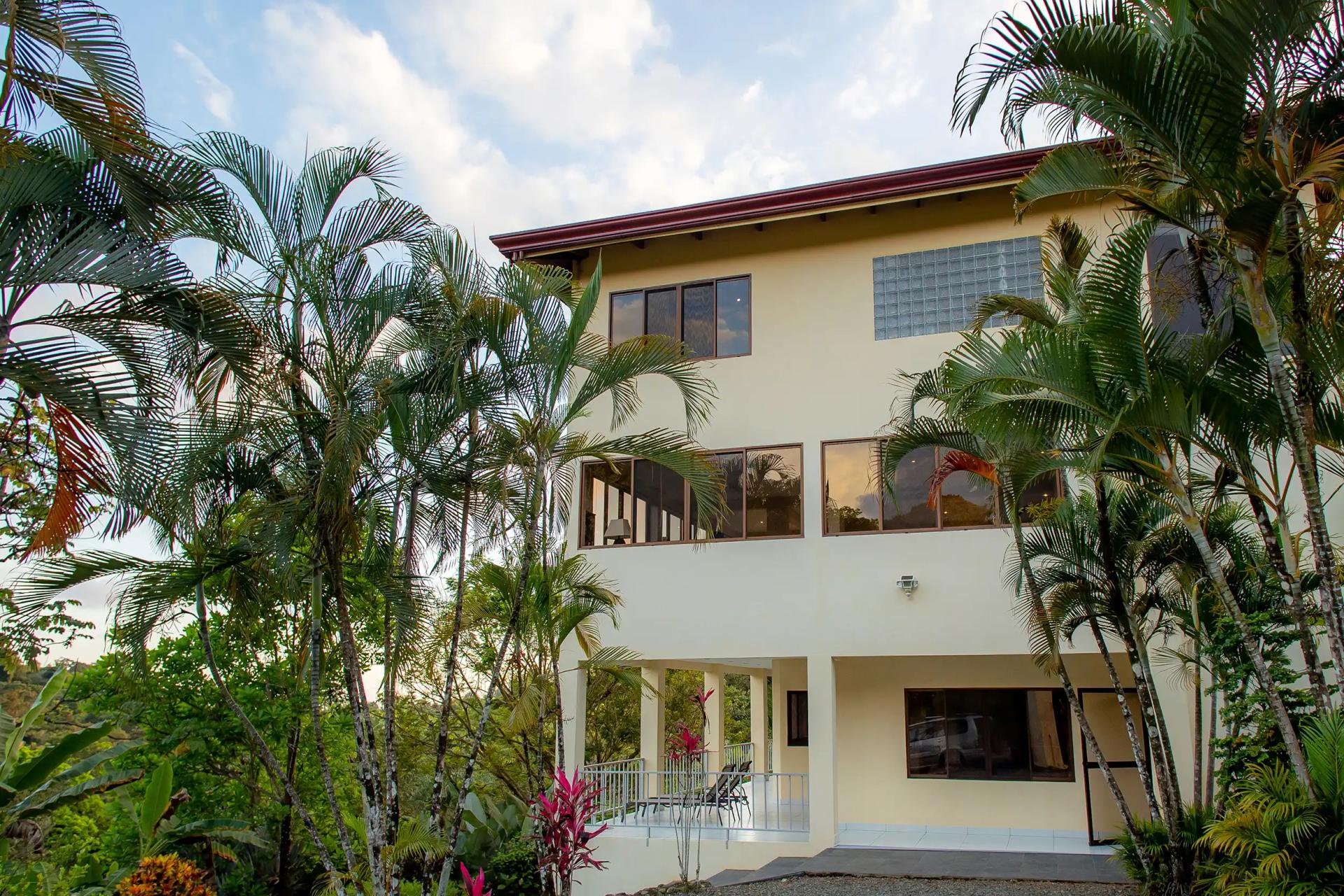 Palm trees frame the three story facade of Casa Mariposa