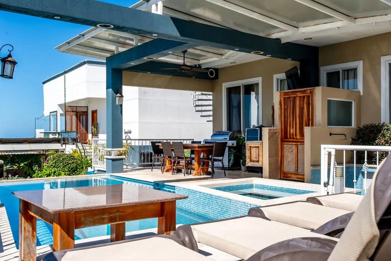 Lounge chairs and hot tub under the poolside pergola at Casa Alta Vista