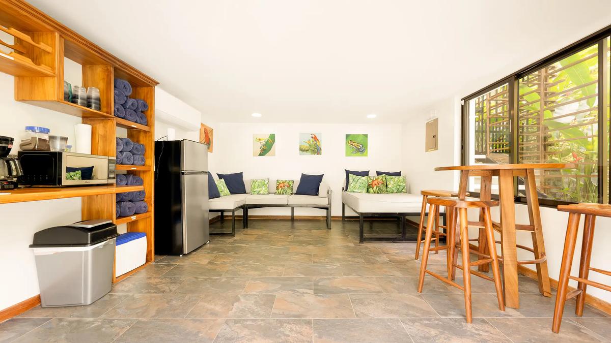 Casa Vista Verde pool lounge with daybeds, rolled towels, and a wooden bar table