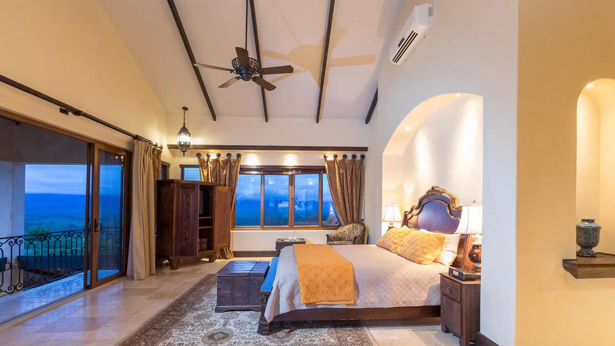 Vaulted master bedroom at Villa Marbella opening to a balcony over the valley