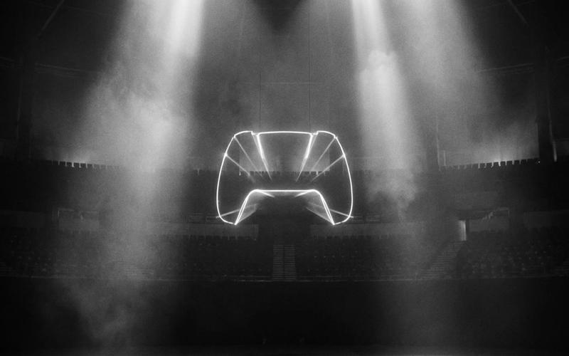 A glowing game controller silhouette in a dark arena