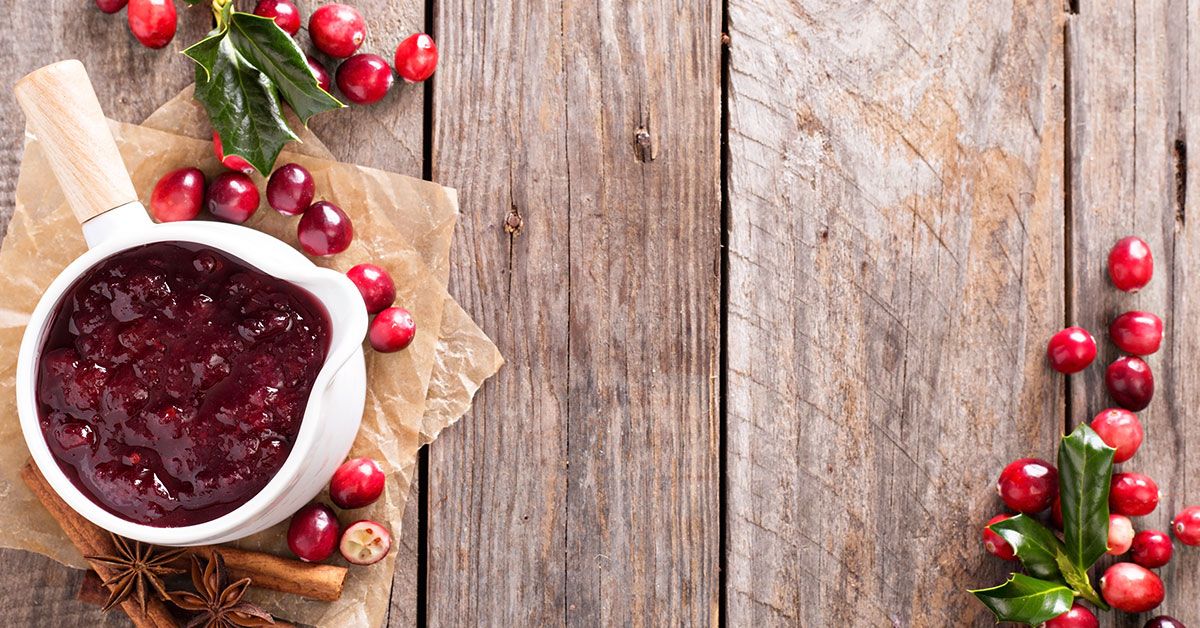 Cranberry sauce and berries on a wooden table.