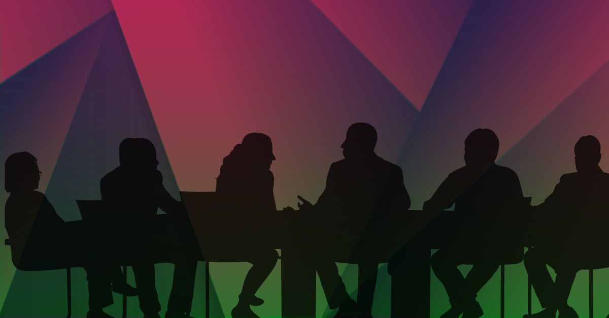 Silhouettes of people sitting at a conference table.