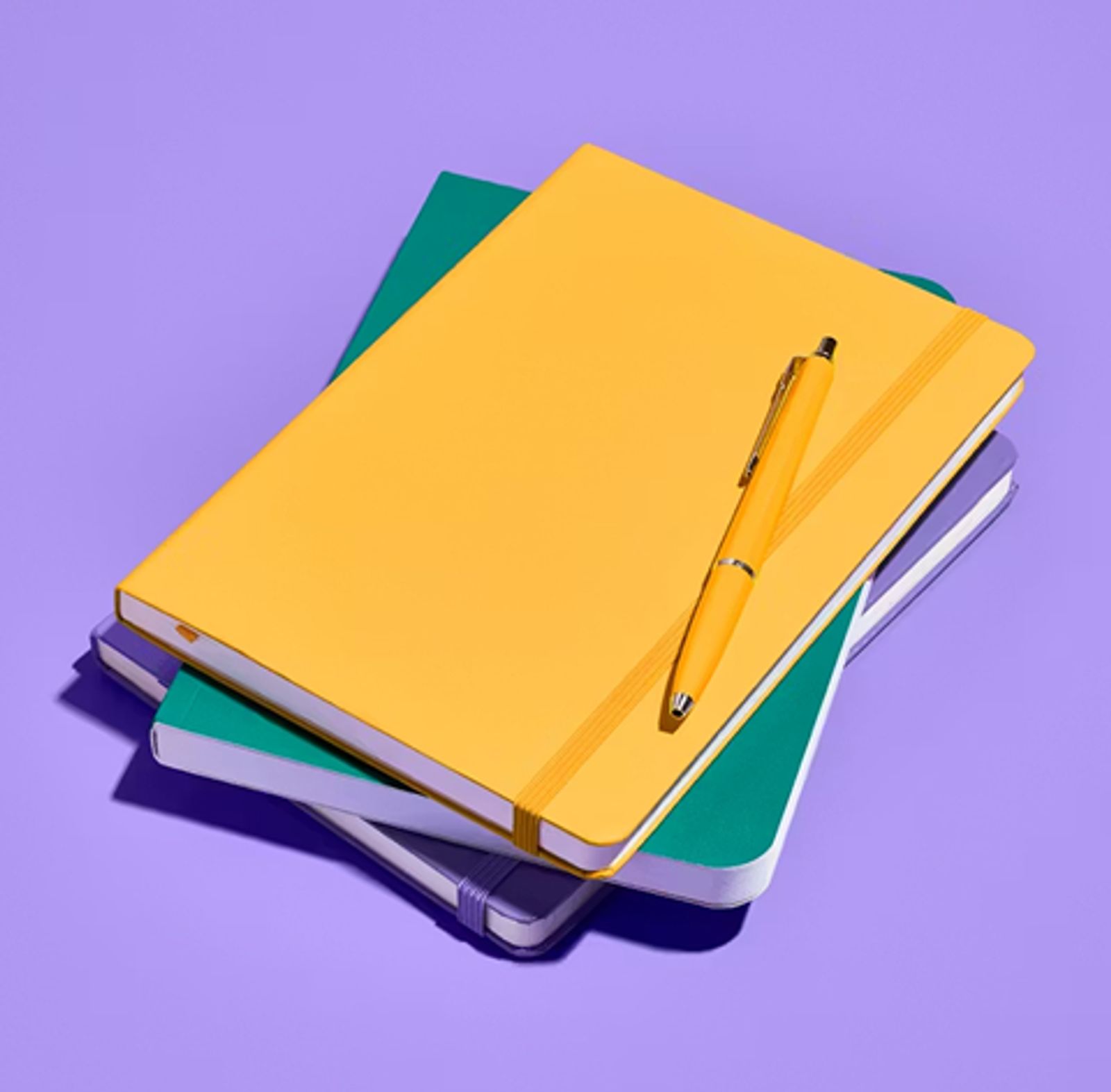Stack of notebooks with a pen on top