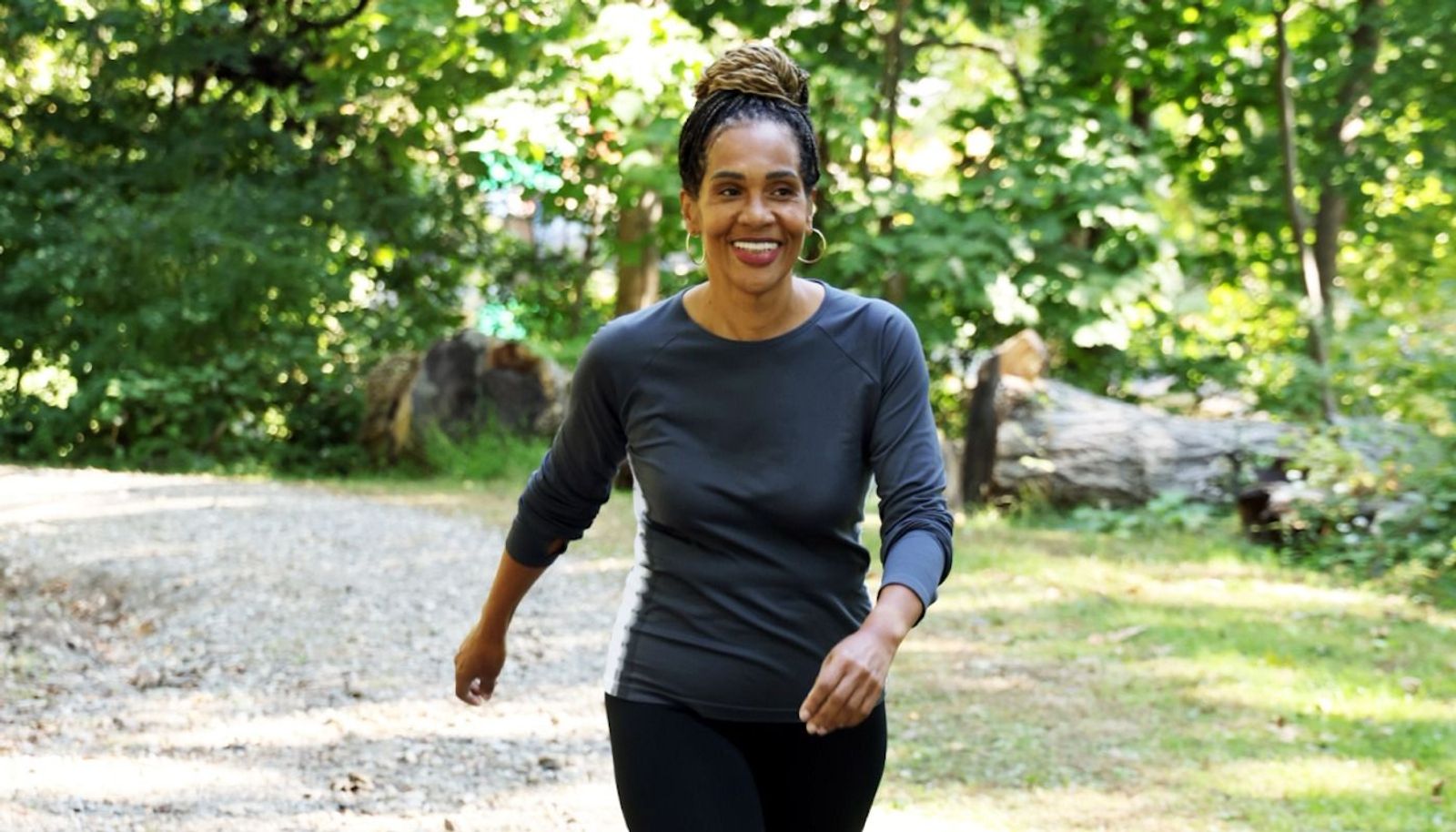 Woman walking outdoors on a path, representing improved health and lifestyle