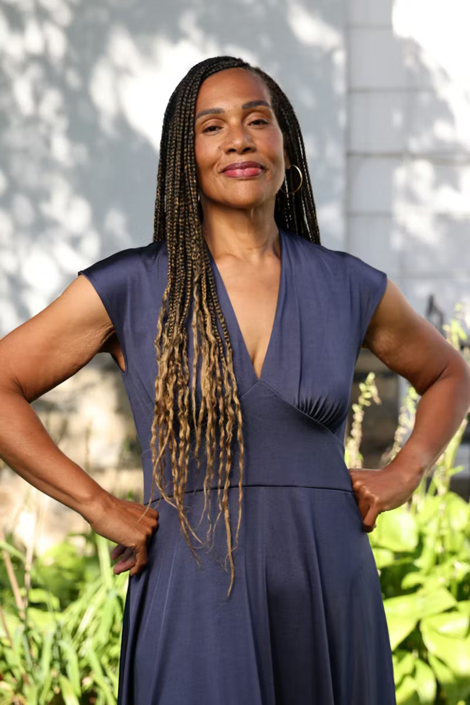 A woman stands confidently with her hands resting on her hips