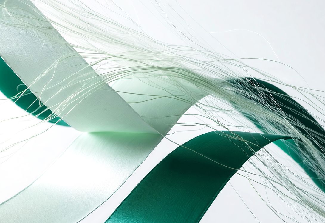 An abstract image of green and white strips of material mixed with what looks like strand of wool, depitcing a 'Data Fabric'