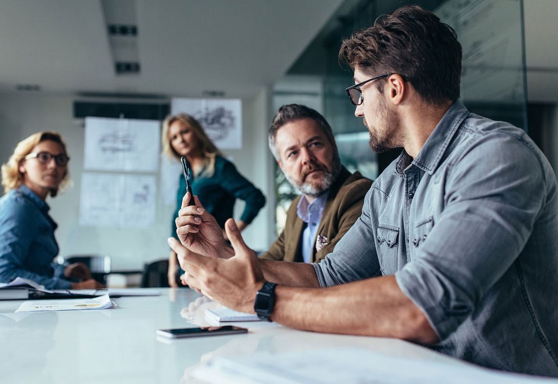 A group of people in an office discussing upgrades to their business applications