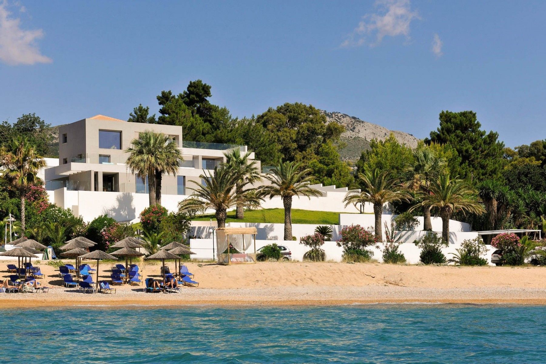 View of the villa’s modern architecture from the sandy beachfront.