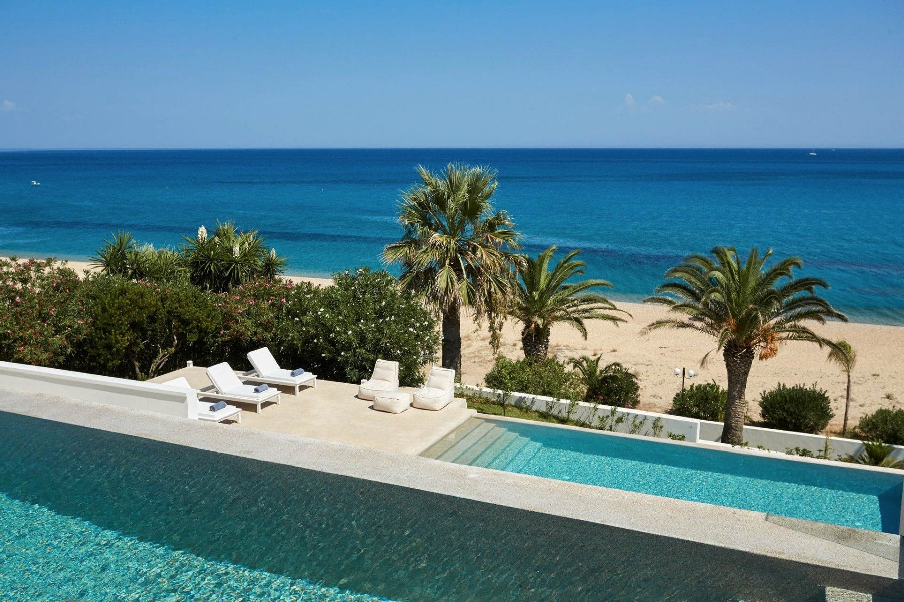 Outdoor pool area with stylish sun loungers and stunning sea views.