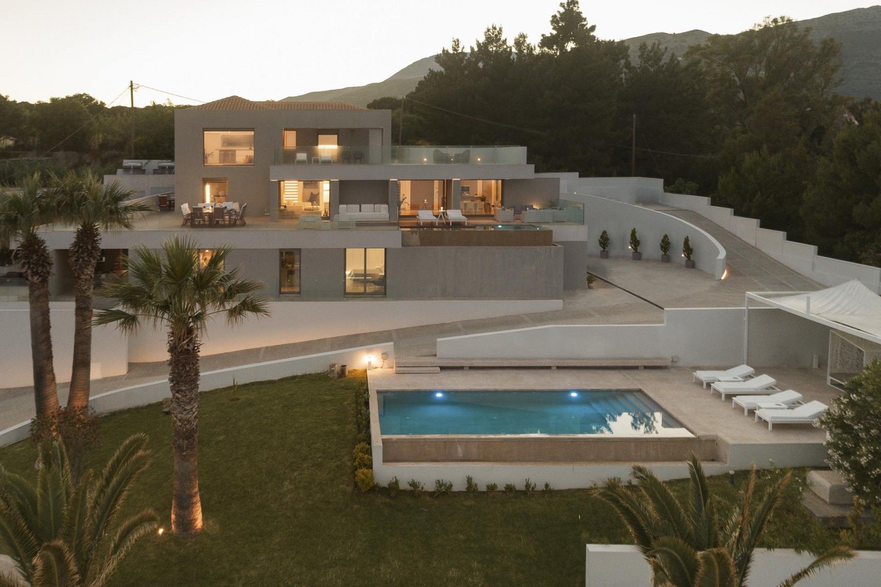 Illuminated pool and villa at sunset, showcasing minimalist architecture at SeaClusion Luxury Villa.