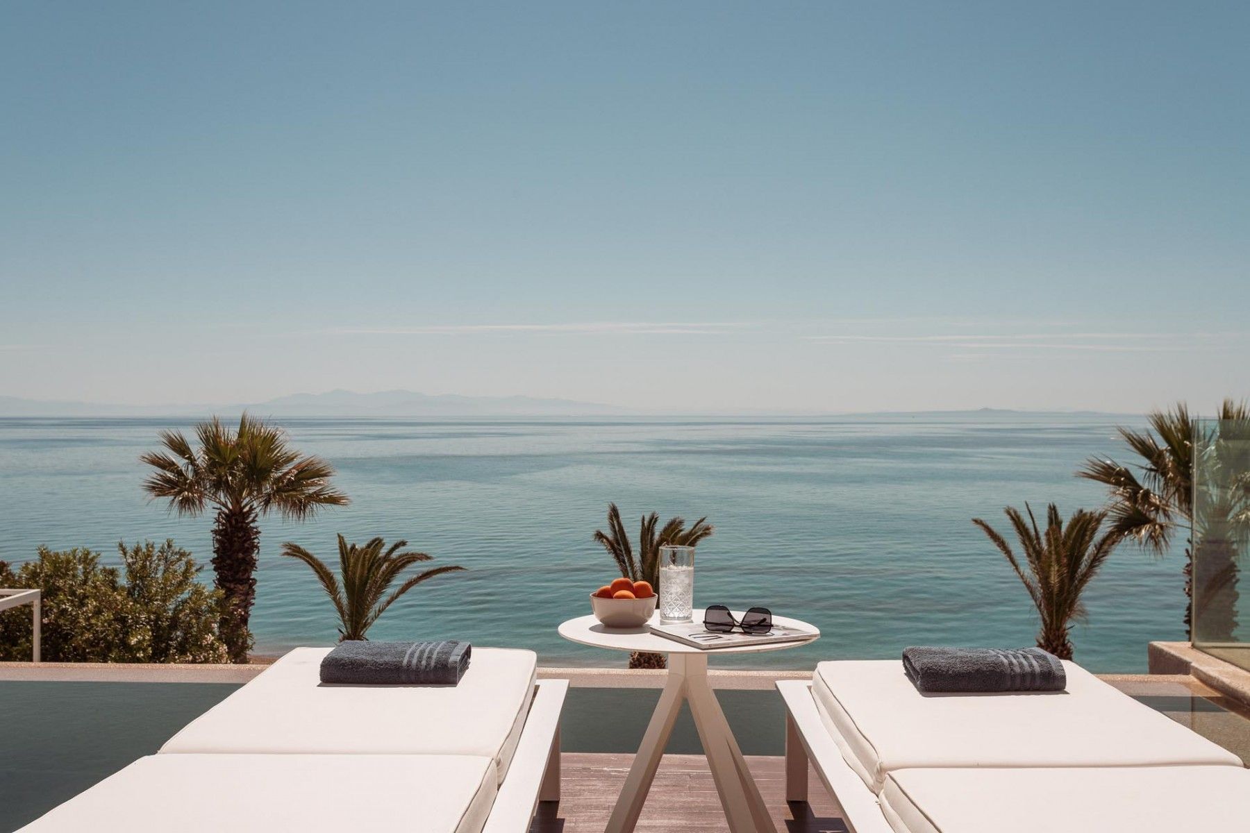 Sunlit pool and shaded lounge chairs at SeaClusion Luxury Villa.