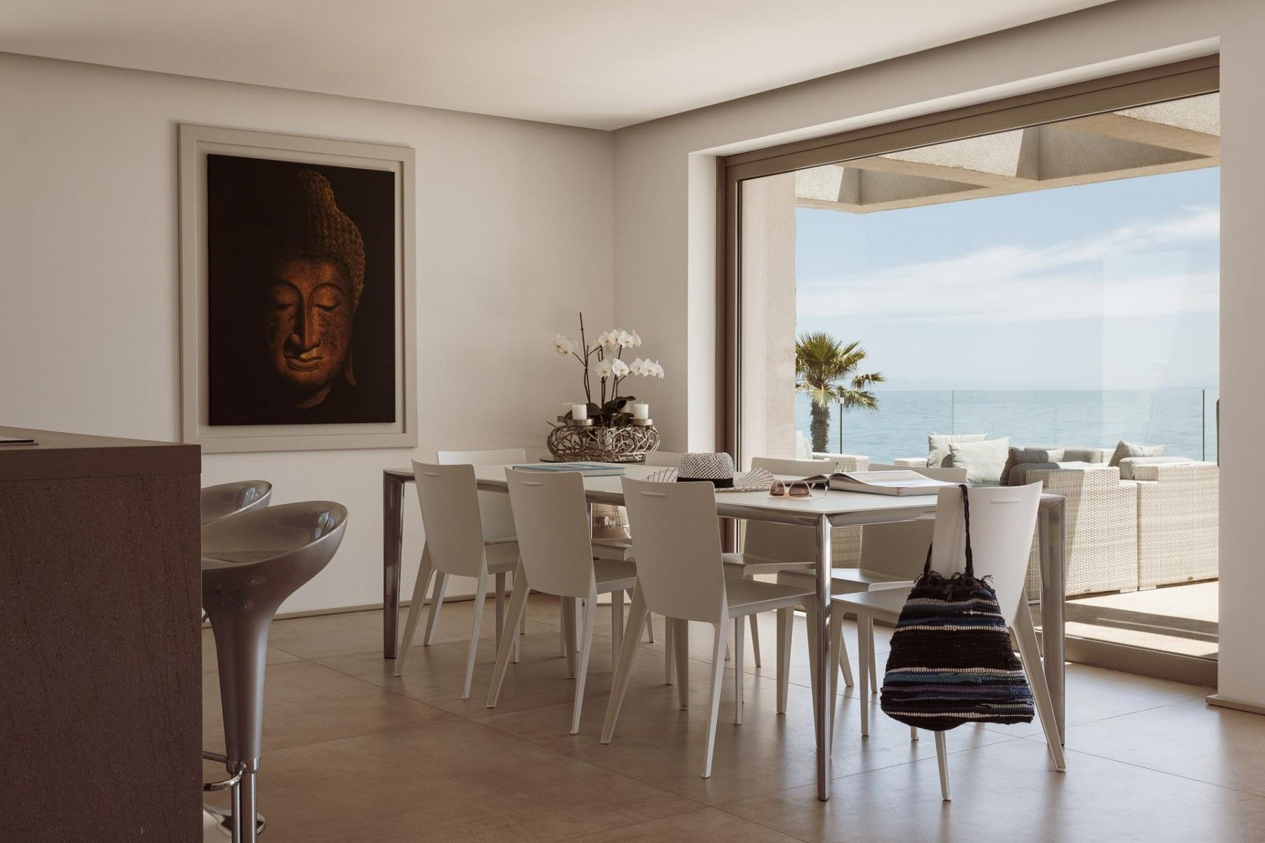 Elegant dining area with modern white chairs overlooking the ocean at SeaClusion Luxury Villa.