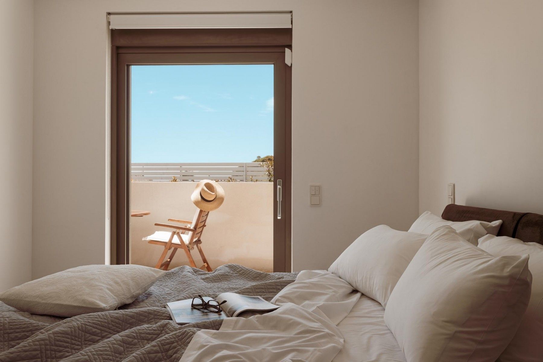 Minimalist bedroom with a double bed, open space, and natural lighting.