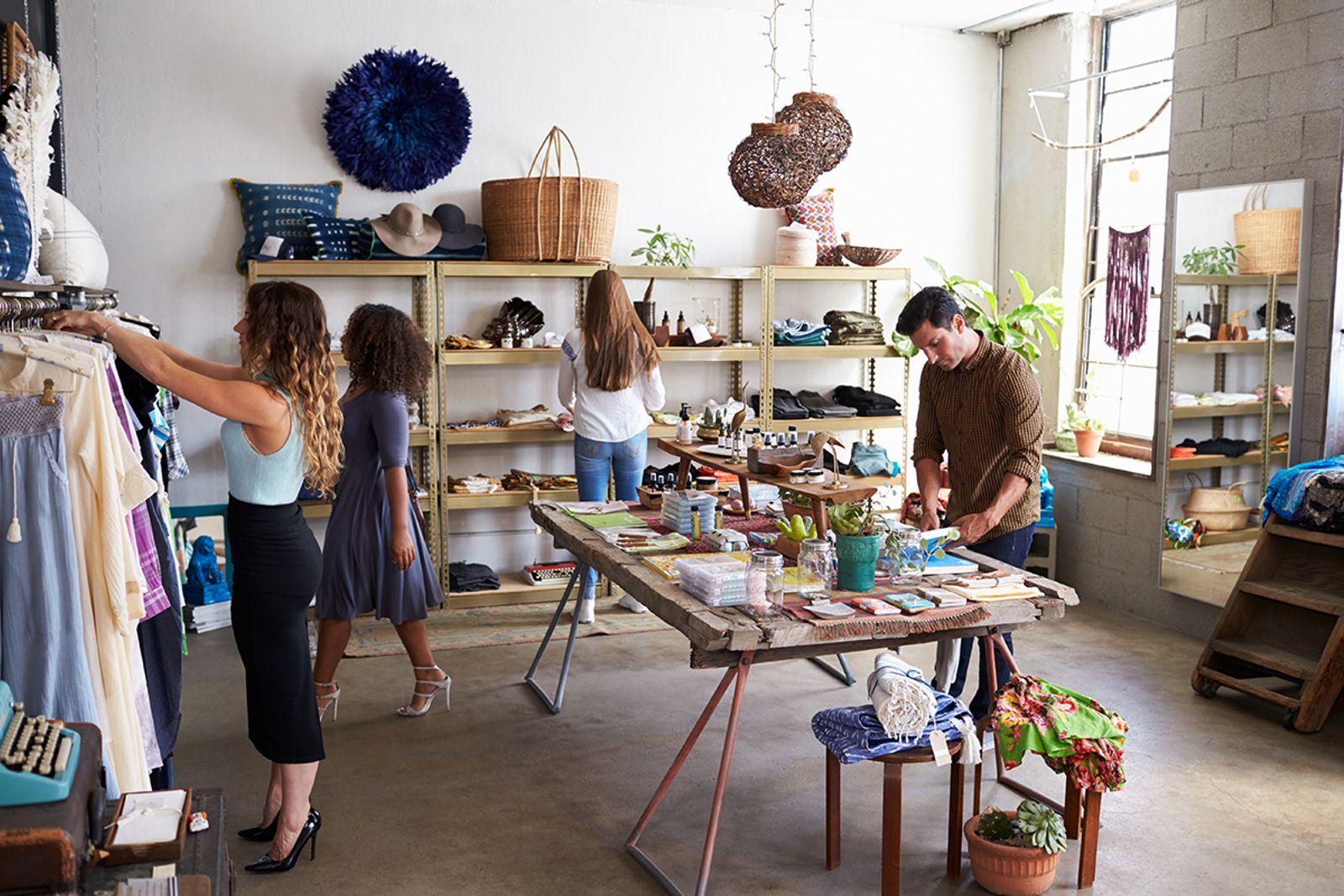 Shoppers browsing clothing and goods inside a bright independent retail boutique