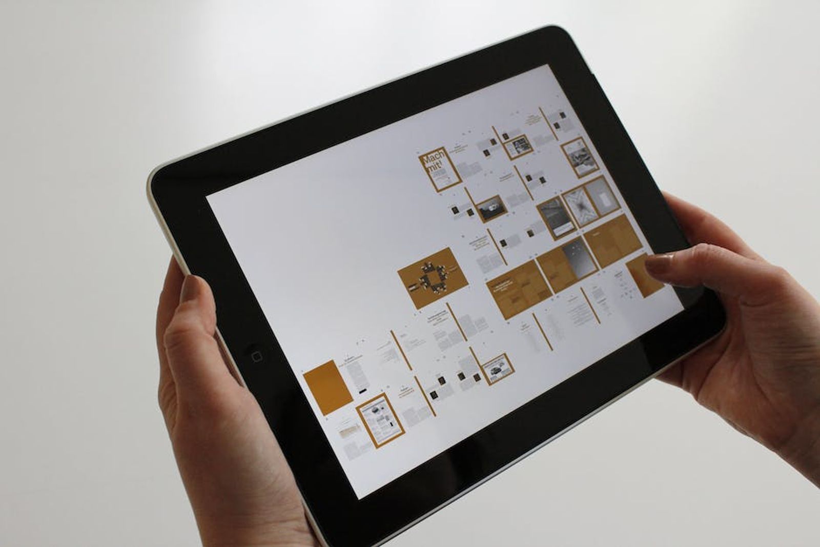 Hands holding a tablet displaying a media plan layout of ad placements and pages