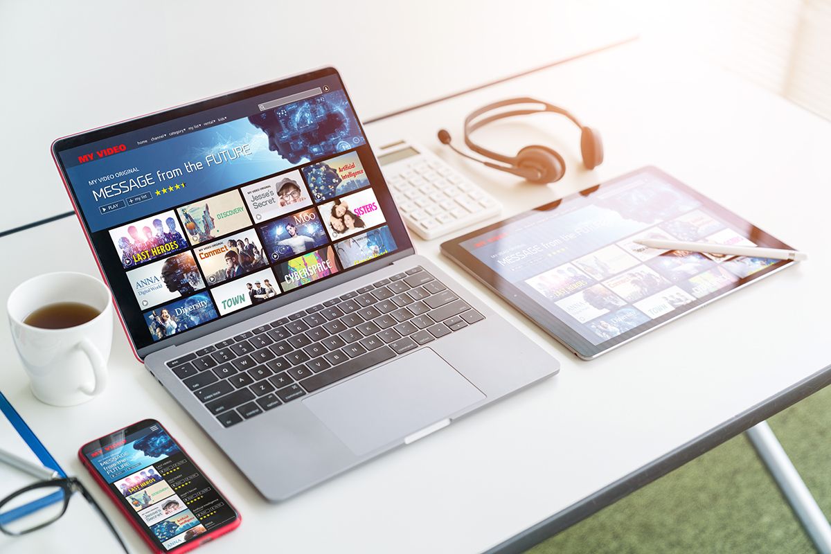 Laptop, tablet and phone showing a streaming video ad platform on a bright desk