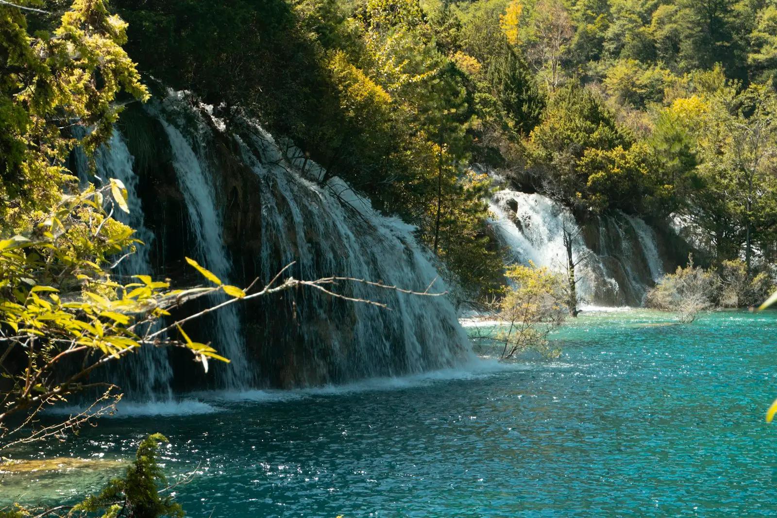 Air terjun bertingkat mengalir ke danau toska di Jiuzhaigou