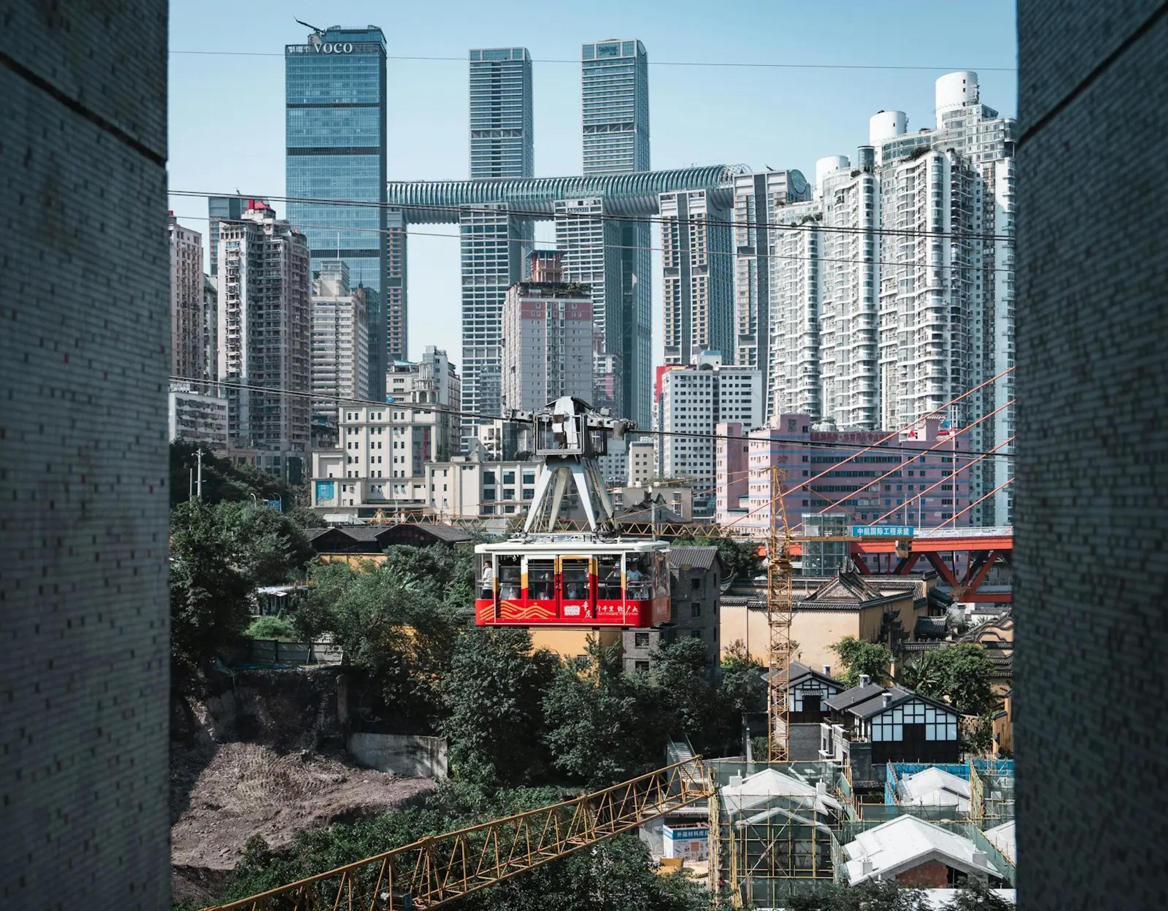 Kereta merah melintas di antara gedung tinggi Yuzhong, Chongqing