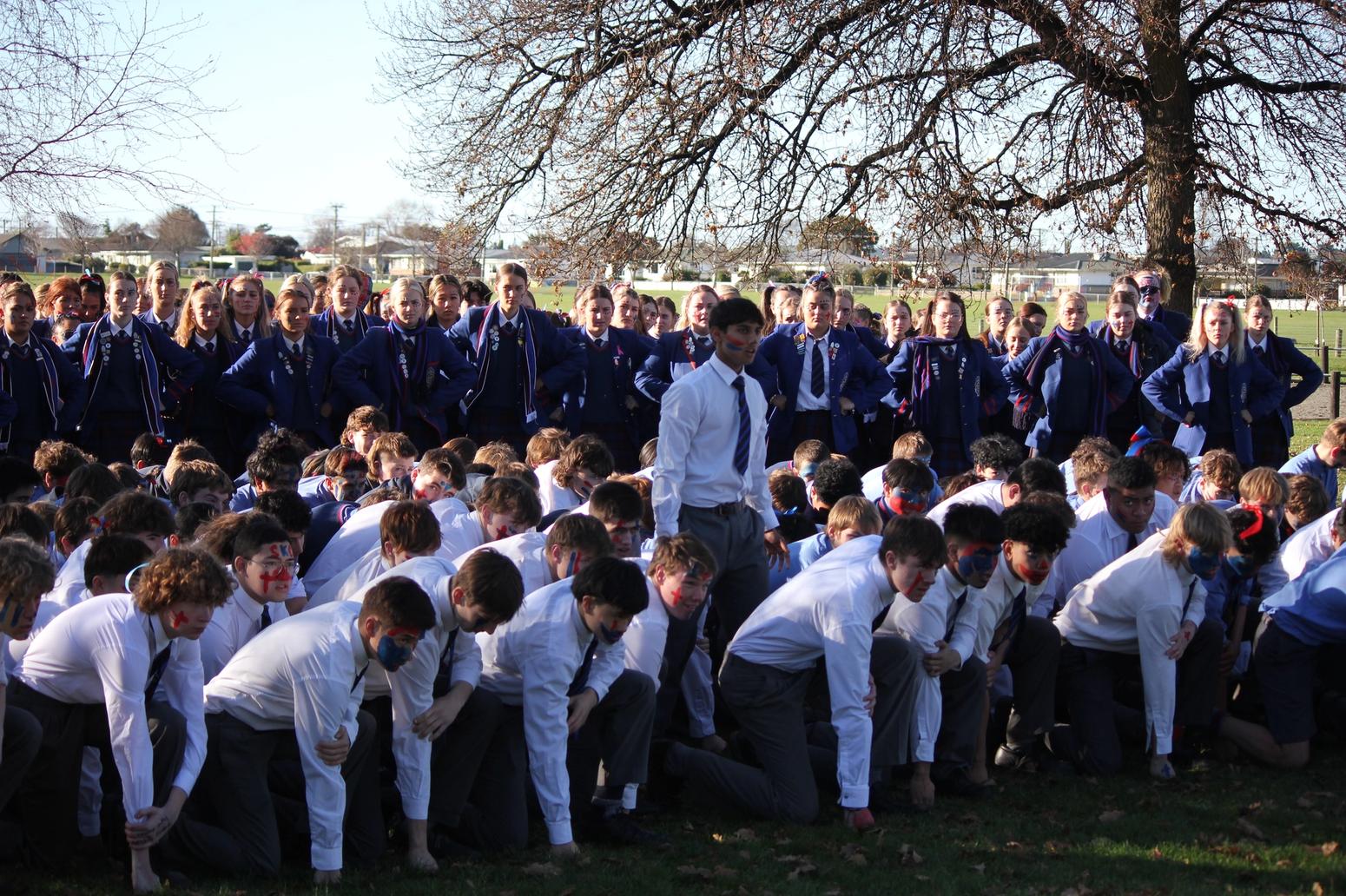 Gruppe von Jugendlichen in traditioneller Maori-Tracht während einer Aufführung.“