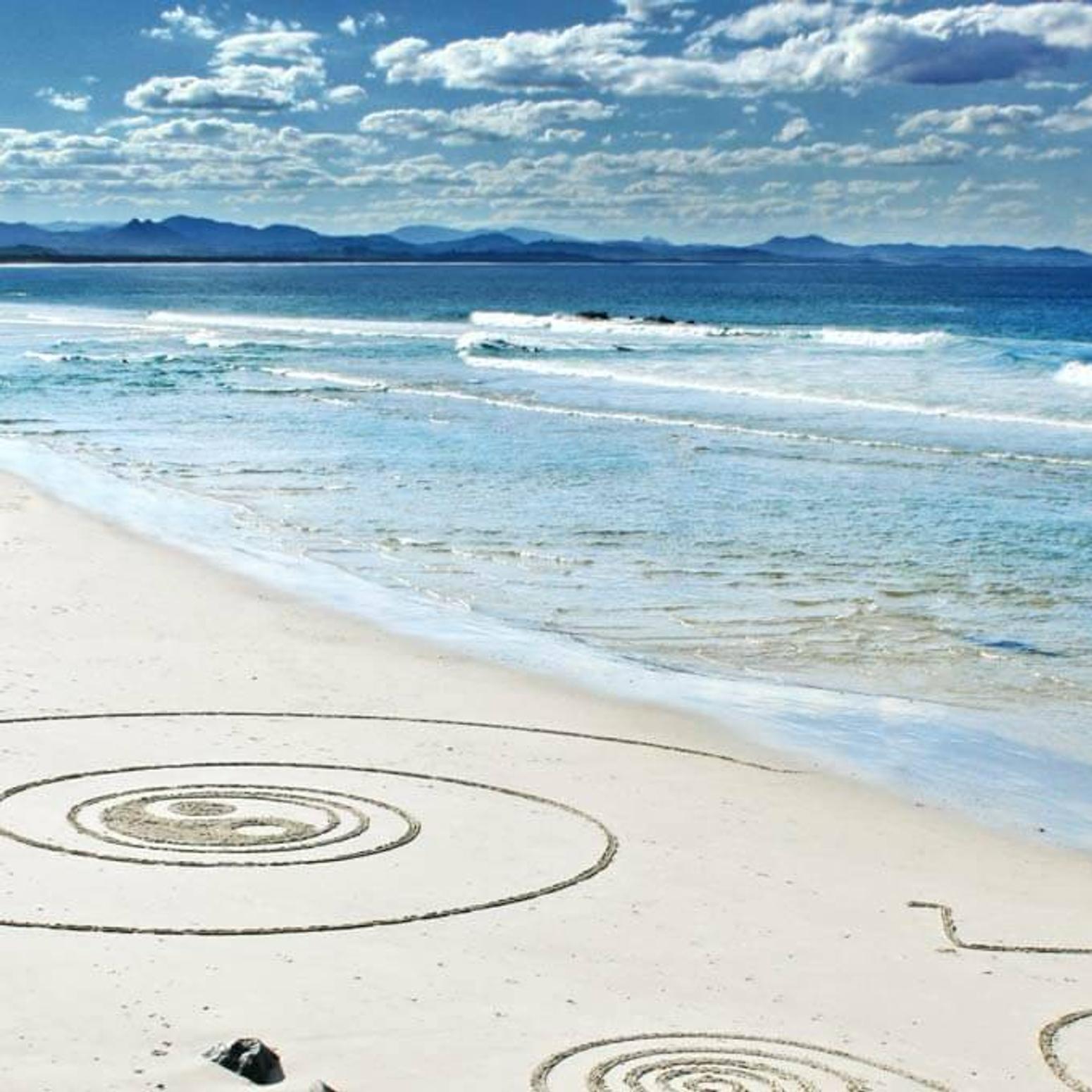 Bild von einem Strand, wo Kreise in den Sand gemalt wurden 