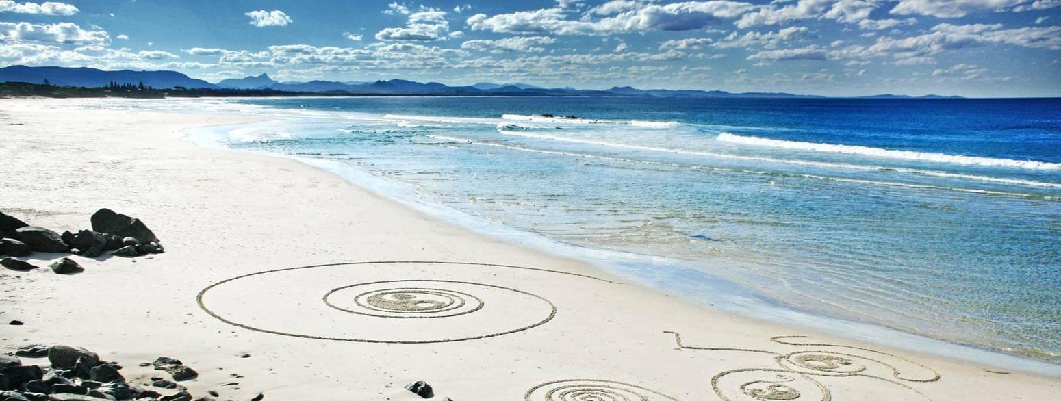 Bild von einem Strand, wo Kreise in den Sand gemalt wurden 
