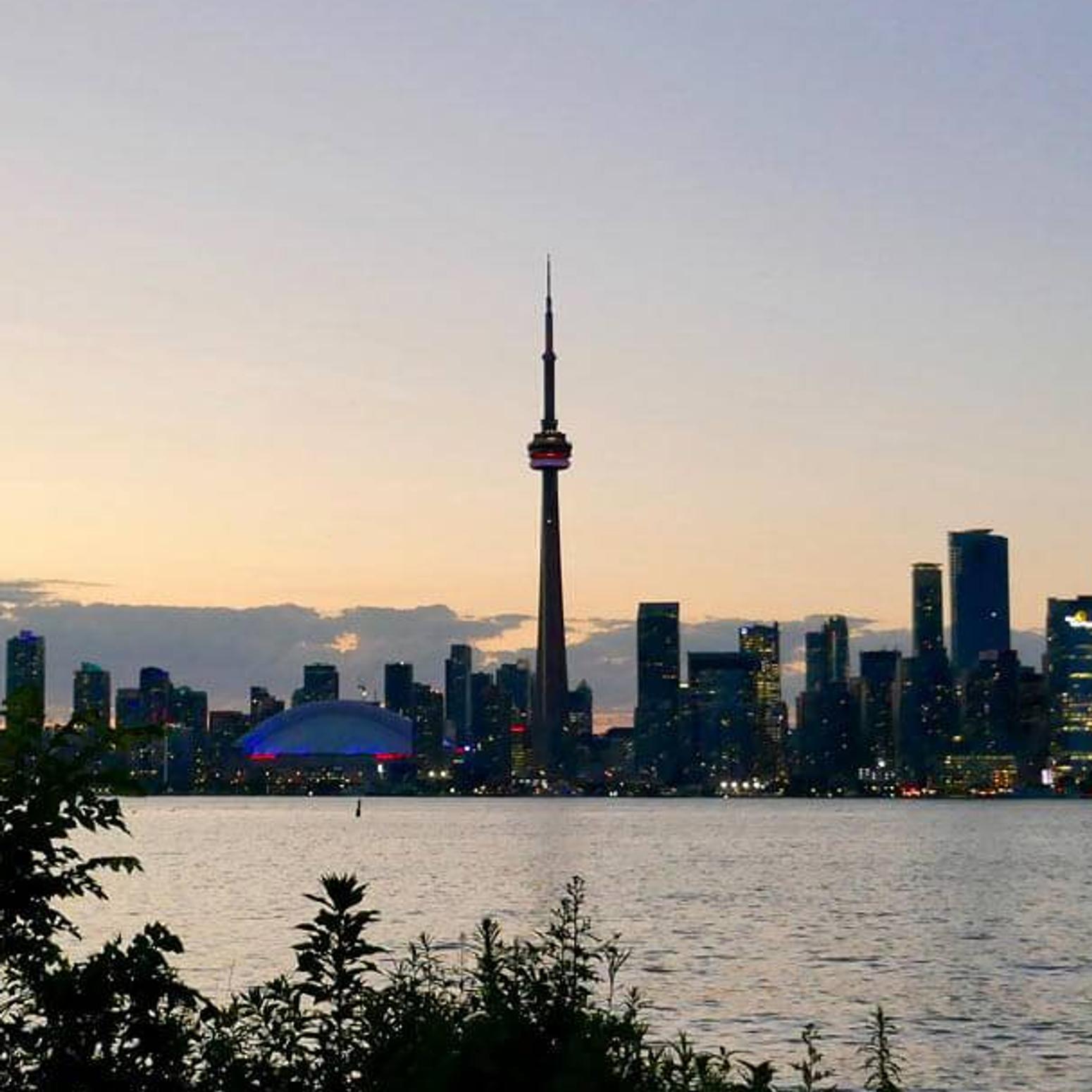 Eine Person steht vor der Skyline einer kanadischen Stadt