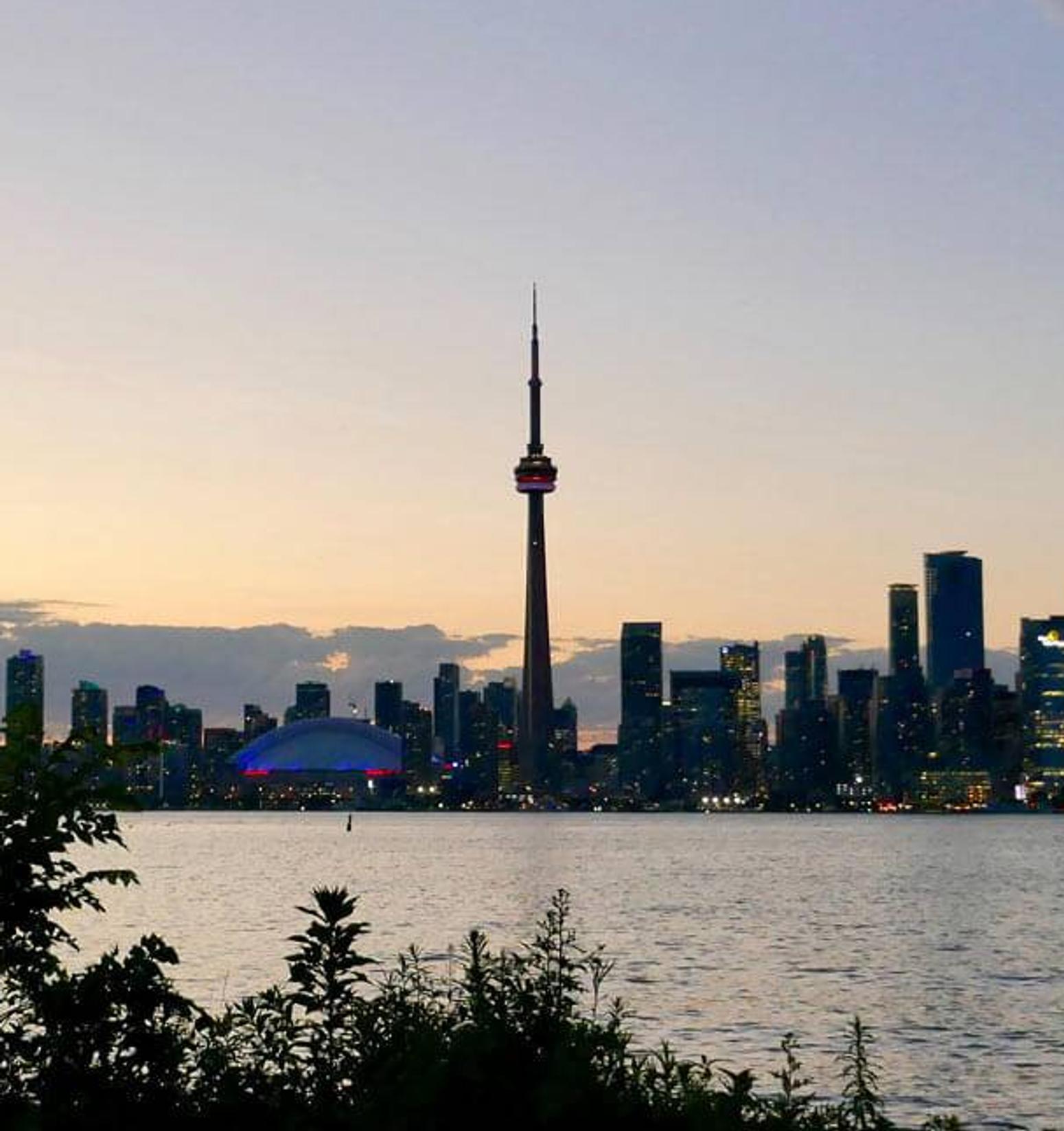 Eine Person steht vor der Skyline einer kanadischen Stadt