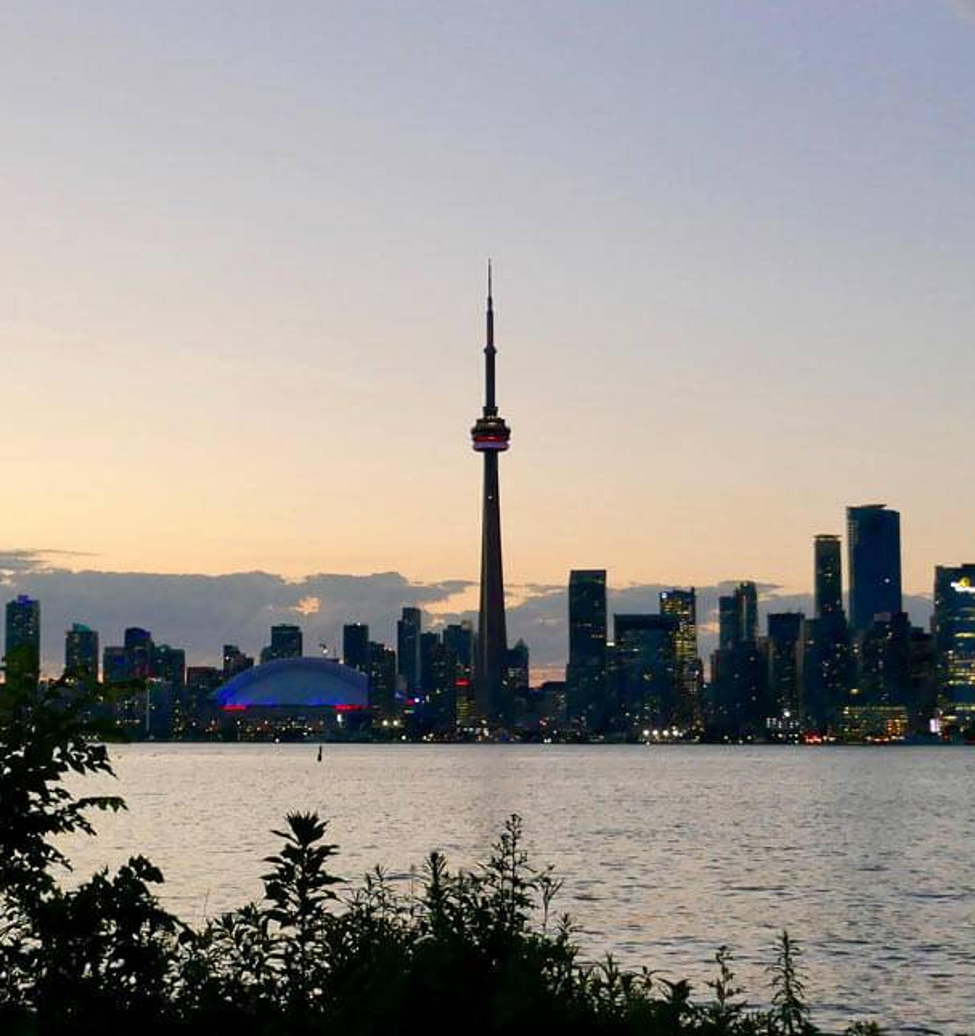 Eine Person steht vor der Skyline einer kanadischen Stadt